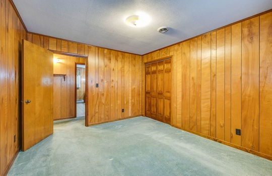 bedroom, closet, paneling walls, carpet, door to hallway