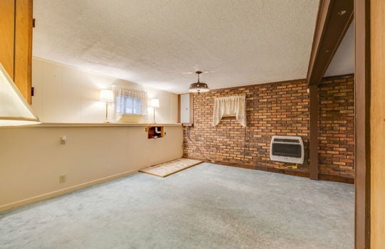 lower level living area, brick feature wall, windows, carpet