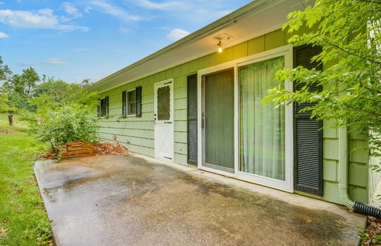 patio, concrete pad, entry door, sliding glass door, wood paneling