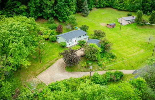 103aerial view of home, driveway, landscaping, front yard, back yard, trees, workshop, split level home, wood siding, brick, front door, neighboring homes