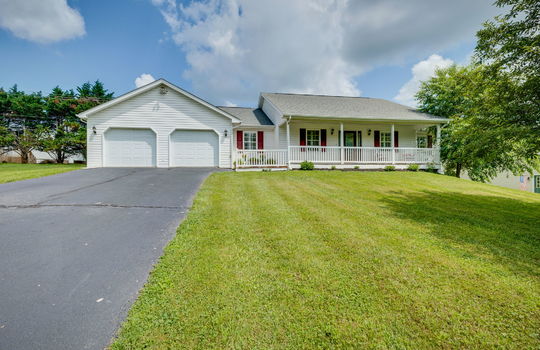 ranch style home, driveway, front yard, tree, covered front porch, two car attached garage, vinyl siding