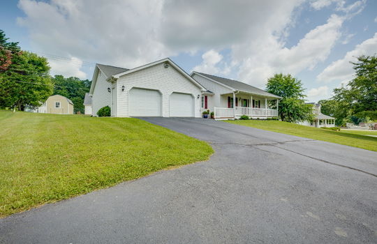 ranch style home, driveway, front yard, two car attached driveway, covered front porch, vinyl siding, front door, landscaping