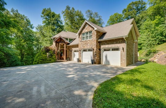 Two story traditional home, driveway, three car garage, brick home exterior, stone home exterior, two stories, front door, roof