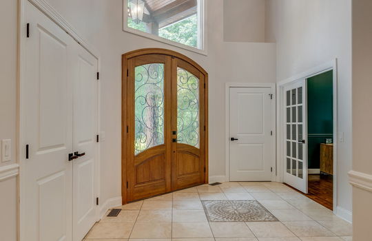 entryway, door to office, tile flooring, chandelier, front door