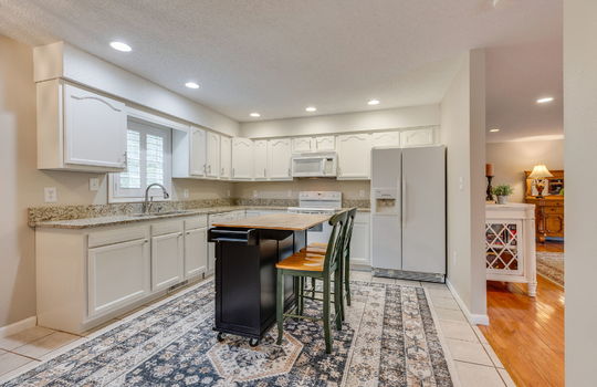 doorway to living room, kitchen, recessed lighting, tile flooring, granite countertops, white cabinets, sink, dishwasher, built in microwave, oven/range, refrigerator