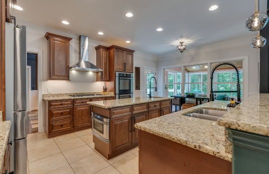 kitchen, tile flooring, cabinets, granite countertops, double wall oven, refrigerator, cooktop, sink, kitchen island, sink in island, kitchen sink, granite countertops, recessed lighting, microwave in island