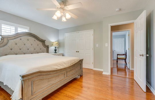 primary bedroom, closet, ceiling fan, hardwood flooring, window, door to hallway
