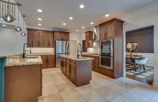 kitchen, tile flooring, cabinets, granite countertops, double wall oven, refrigerator, cooktop, sink, kitchen island, sink in island, kitchen sink, granite countertops, recessed lighting