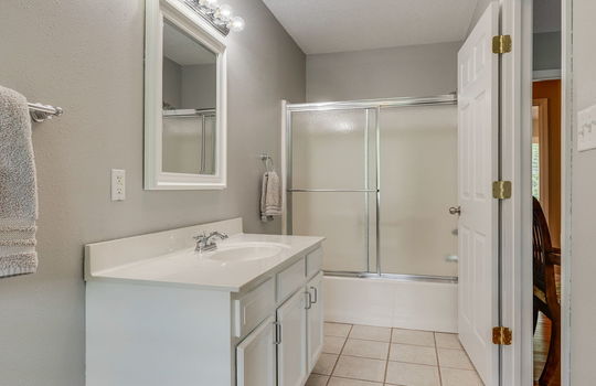 ensuite bathroom in second bedroom, tile flooring, sink, shower/tub
