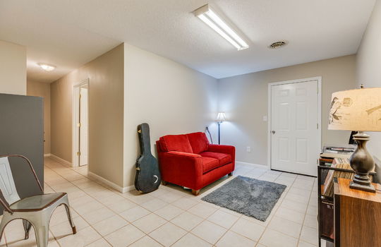 lower level finished space, tile flooring, fluorescent lighting, door