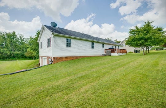 back yard, back deck, vinyl siding, trees, lower level garage door