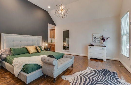 primary bedroom, wet bar, hardwood flooring, vaulted ceiling, light fixture, windows