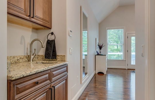 wetbar, sink, granite countertops, hardwood flooring