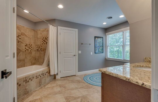 bathroom, granite counters, sink, shower/tub, tile shower walls, tile flooring