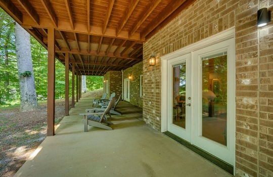 covered back patio, brick exterior, windows, exterior entry doors