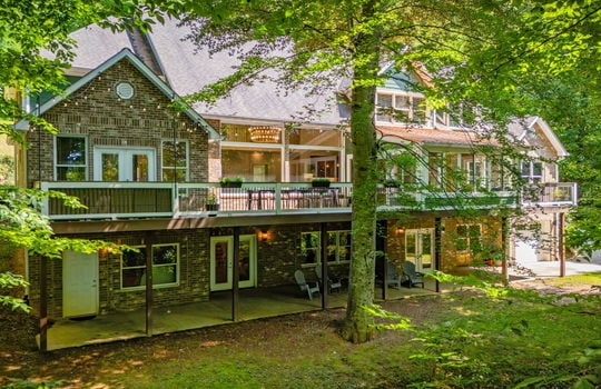 front of home, brick exterior, back deck, covered back patio, windows, exterior entry doors, trees, garage