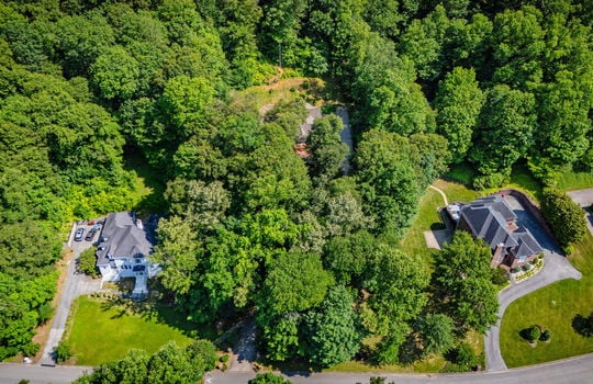 aerial view of property, neighboring homes, roof, trees