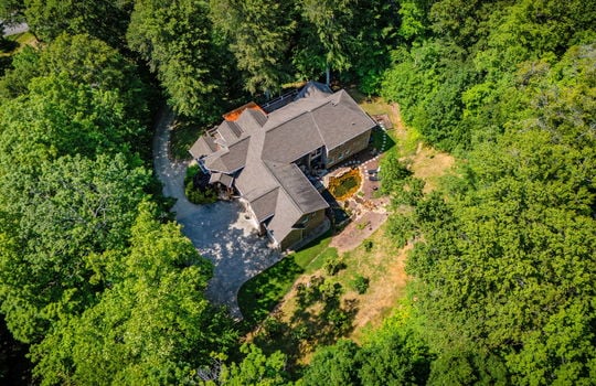 aerial view from back of property, back yard, pond, roof, driveway, trees