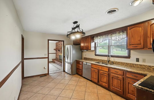 kitchen, stainless appliances, refrigerator, dishwasher, sink, granite counters, window above sink, cabinets, pot rack light, tile flooring