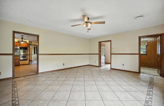den, tile flooring, ceiling fan, door to office, door to kitchen