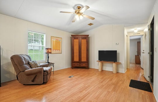 living room, laminate flooring, front door, door to second bedroom, ceiling fan