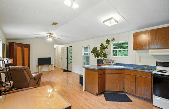 kitchen, countertops, sink, oven/range, living room, laminate flooring, ceiling fan