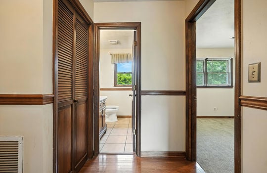 hallway, linen closet, hardwood flooring, door to bedroom, door to bathroom