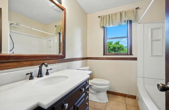 bathroom, tile flooring, shower/tub, toilet, sink, window