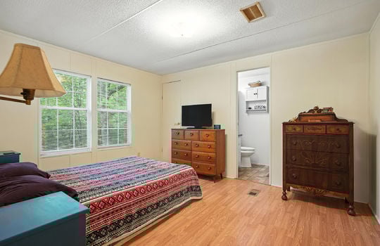 primary bedroom, laminate flooring, closet, ensuite bathroom door, windows