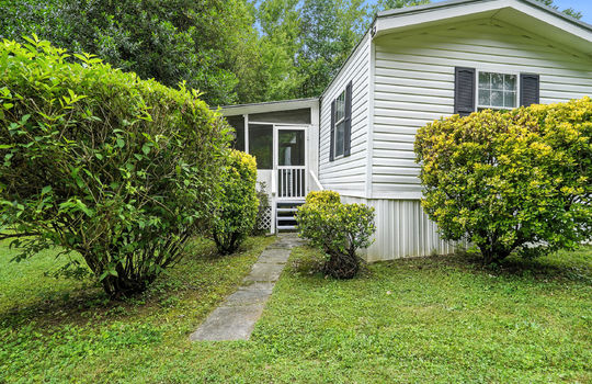 singlewide, vinyl siding, covered front porch, screened porch, landscaping, sidewalk, wooden stairs