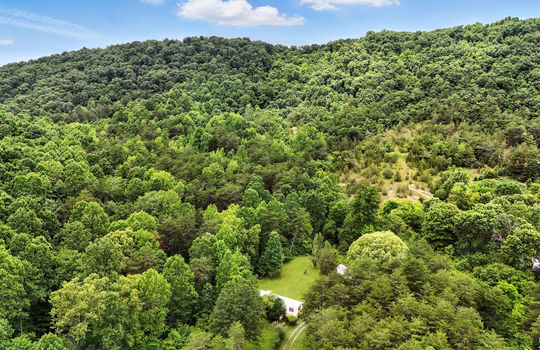 aerial view of property, front yard, back yard, gravel driveway, trees, mountains