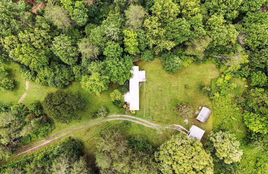 aerial view of property, singlewide, metal roof, back deck, covered front porch, front yard, back yard, trees, carport