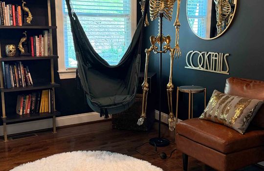 golden fake skeleton in sitting room, hardwood flooring, window, light fixture