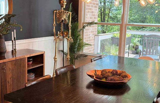 golden fake skeleton in dining area, light fixture, large windows