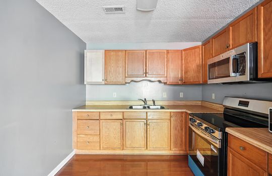 kitchen, sink, built in microwave, oven/range, cabinets, countertops