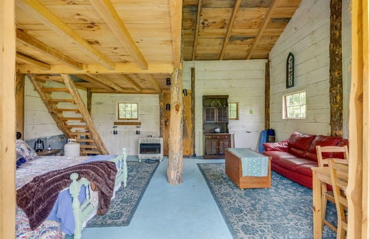 cabin interior, wood walls, wood ceiling, loft, wooden stairs, one room cabin