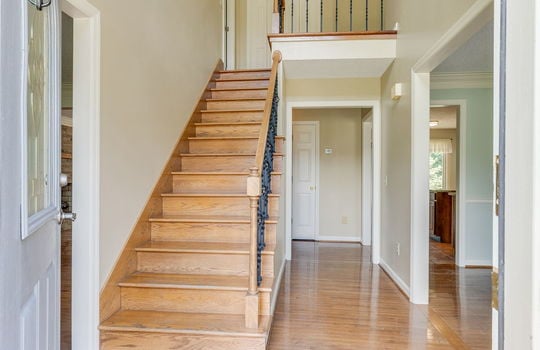 foyer, entryway, stairs to upper level, door to living space, front door, hardwood flooring, wooden stairs
