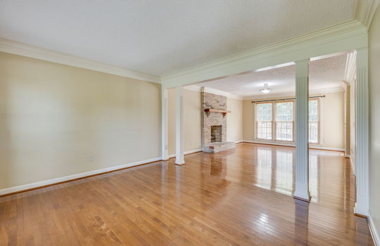 formal living area, brick fireplace, windows, hardwood flooring