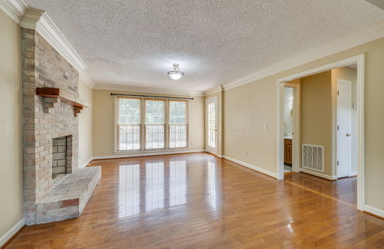 formal living area, brick fireplace, hardwood flooring