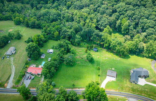 aerial photo of property, road, trees, shed, cabin, neighboring homes