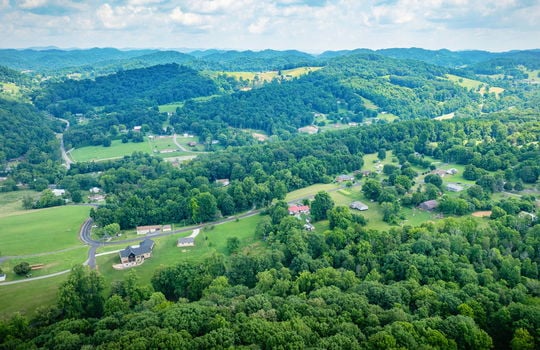 aerial view of property, mountain views, road, neighboring homes