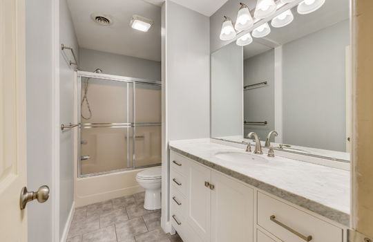 bathroom, shower/tub, sliding glass shower door, toilet, sink, cabinet