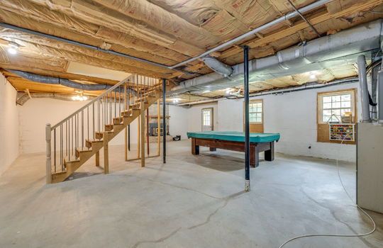 basement, unfinished basement, concrete flooring, stairs to main level, fireplace, exterior door, windows