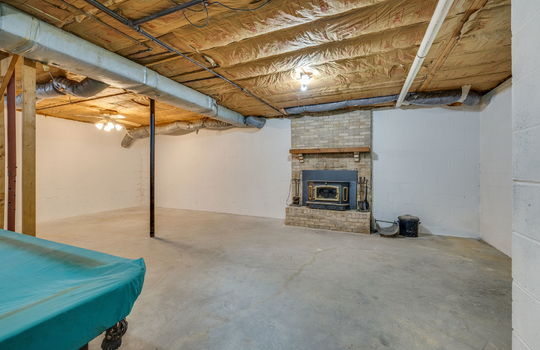 basement, unfinished basement, concrete flooring, stairs to main level, fireplace, exterior door, windows