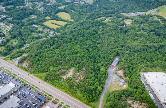 aerial photo, undeveloped land, 48+/- acres, commercial land for sale, trees, neighboring businesses, stone drive, mountain views, 1100'+ Road Frontage, prime Kingsport Location