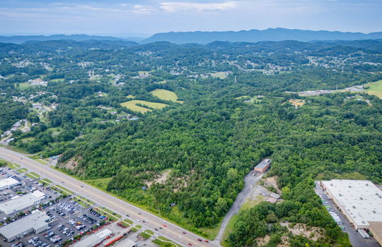 aerial photo, undeveloped land, 48+/- acres, commercial land for sale, trees, neighboring businesses, stone drive, mountain views, 1100'+ Road Frontage, prime Kingsport Location
