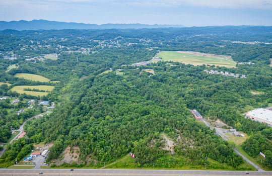 aerial photo, undeveloped land, 48+/- acres, commercial land for sale, trees, neighboring businesses, stone drive, mountain views, 1100'+ Road Frontage, prime Kingsport Location