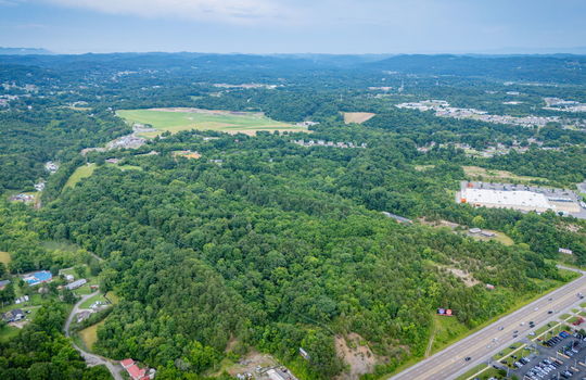 aerial photo, undeveloped land, 48+/- acres, commercial land for sale, trees, neighboring businesses, stone drive, mountain views, 1100'+ Road Frontage, prime Kingsport Location