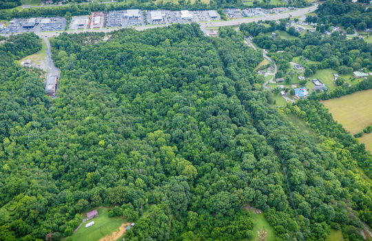 aerial photo, undeveloped land, 48+/- acres, commercial land for sale, trees, neighboring businesses, stone drive, mountain views, 1100'+ Road Frontage, prime Kingsport Location