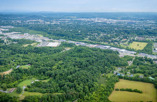 aerial photo, undeveloped land, 48+/- acres, commercial land for sale, trees, neighboring businesses, stone drive, mountain views, 1100'+ Road Frontage, prime Kingsport Location